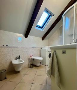 a bathroom with a sink and a toilet and a window at Mokka Loft in Biella