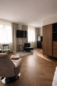 a living room with a chair and a television at Studio Odrodzenia 5 Centrum Lubina in Lubin +9 photos