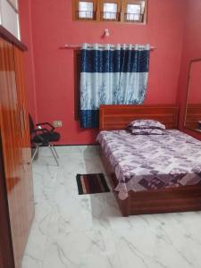 a bedroom with a bed and a red wall at A Homestay in Amingaon +2 photos