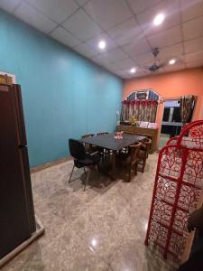 a room with a ping pong table and chairs at A Homestay in Amingaon