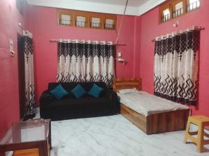 a living room with a bed and a couch at A Homestay in Amingaon