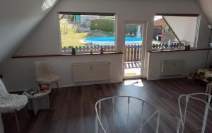 a living room with a view of a swimming pool at Weitblick am Hankehübel in Hohnstein