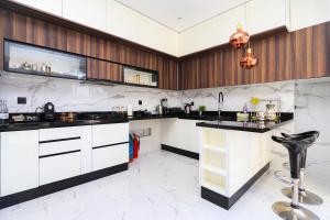 a kitchen with white cabinets and black counter tops at Villa Perle mémorable séjour vous attendent in Tétouan