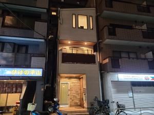 a building with a door in the middle of a street at Greci Art Tokyo グレーチアート東京 in Tokyo