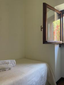 a small bedroom with a bed and a window at Lakefront holiday in Salò