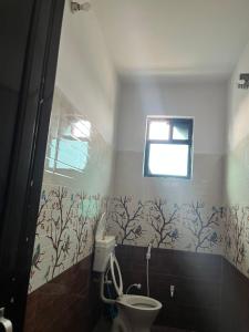 a bathroom with a toilet and a window at Rr Complex in Nalmatha