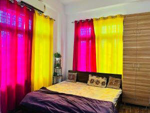 a bedroom with bright colored curtains and a bed at Rr Complex in Nalmatha