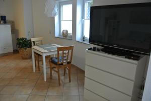 a living room with a television and a table with chairs at Ferienwohnung in Bad Schwalbach in Bad Schwalbach