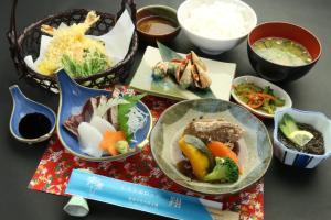 a table topped with plates of food and bowls of food at Rest and Lodge Syou in Amami