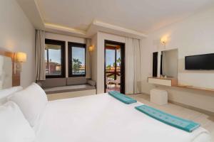 a bedroom with a large white bed with a flat screen tv at Sundia By Liberty Suncity in Oludeniz