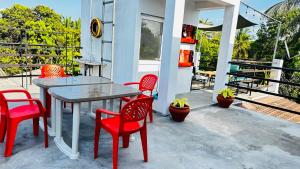 a table and four chairs on a porch with a table and chairsktop at Infinity Villa in Anuradhapura
