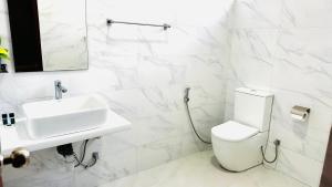 a white bathroom with a sink and a toilet at Infinity Villa in Anuradhapura +29 photos