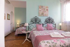 a bedroom with two beds with pink pillows at B&B Dei Cavalieri in Pisa
