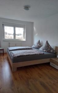 a bedroom with a large bed in a room at Weitblick am Hankehübel in Hohnstein +8 photos