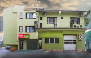 ein grün-weißes Gebäude mit einem Schild darauf in der Unterkunft Mix Hotel in Widin