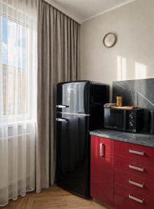 a kitchen with a black refrigerator and a microwave at Studio Odrodzenia 5 Centrum Lubina in Lubin