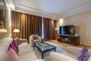 a living room with a couch and a television at Kenzi Menara Palace & Resort in Marrakesh