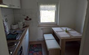 a small kitchen with a table and a window at Weitblick am Hankehübel in Hohnstein