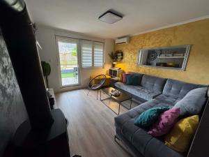 a living room with a gray couch in a room at Neretva Paradise Mostar in Mostar