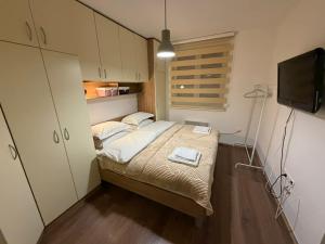 a small bedroom with a bed and a flat screen tv at Neretva Paradise Mostar in Mostar