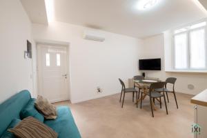 a living room with a couch and a table with chairs at Vetera Boutique by IXIHOME in Varese