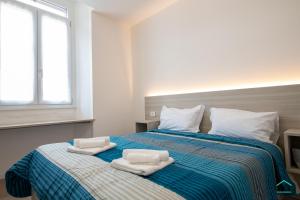 a bedroom with a bed with two towels on it at Vetera Boutique by IXIHOME in Varese