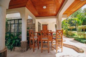 a dining room with a table and chairs on a patio at Karen Crown 5BR Villa in Nairobi