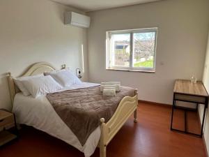 a bedroom with a large bed with a window at Casa Germano in Sabugal