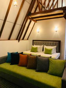 a bedroom with two beds and a green couch at Skyline Haven Ella Cabana in Ella