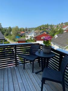 a patio with two chairs and a table with flowers on it at Modern 3BR Apartment Near Oslo Center Free Parking in Lorenskog