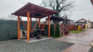 a wooden pavilion with a grill in a yard at Casa SOL in Turda +131 photos