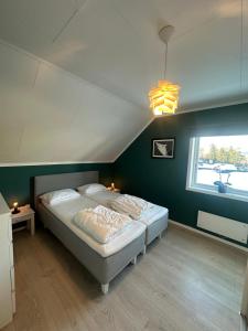 a bedroom with a bed and a large window at Modern 3BR Apartment Near Oslo Center Free Parking in Lorenskog