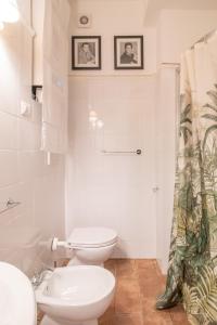 a white bathroom with a toilet and a sink at Boschetto 58 in Rome