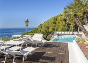 a deck with chairs and a swimming pool and the ocean at Villa Ritter Orizzonte in Cavoli