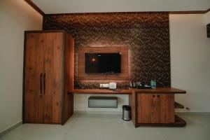 a room with a desk and a tv on a wall at Green View Suites in Kalyānpur