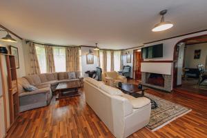 a living room with white furniture and a fireplace at Karen Crown 5BR Villa in Nairobi