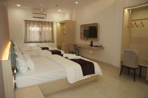 a bedroom with a large white bed and a desk at Samyak Stay in Ujjain +17 photos