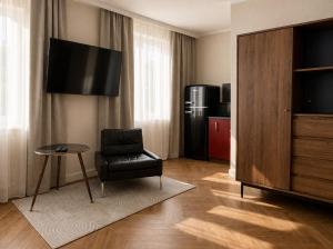a living room with a chair and a television at Studio Odrodzenia 5 Centrum Lubina in Lubin