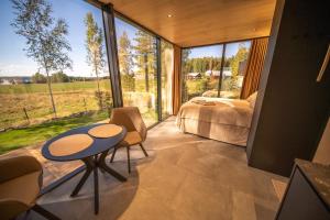 a bedroom with a table and a bed and a large window at Escape - Bollnäs in Bollnäs