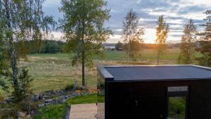 a small black building in a field with trees at Escape - Bollnäs in Bollnäs