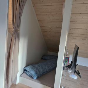 a room with a bed and a desk with a computer at Einzigartige Schlafkojen in Herisau