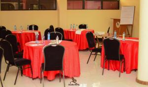 ein Raum mit Tischen und Stühlen mit roten Tischdecken in der Unterkunft Cicada Hotel in Eldoret