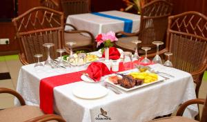 ein weißer Tisch mit einem Teller Essen darauf in der Unterkunft Cicada Hotel in Eldoret