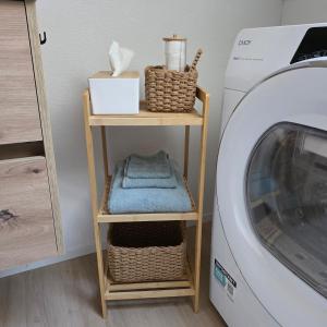 a small wooden shelf next to a washing machine at Einzigartige Schlafkojen in Herisau