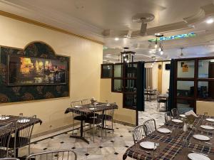 a restaurant with tables and chairs in a room at Hotel Meghdoot in Bhadohī