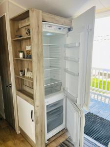 a white refrigerator with its doors open in a room at Calypso Hot Tub Breaks Tattershall Lakes Pet Friendly in Tattershall