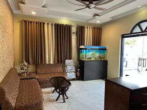 a living room with a couch and a fish tank at Hotel Meghdoot in Bhadohī