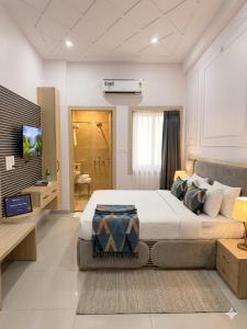 a bedroom with a large bed and a television at Sunrise stay in Mathura