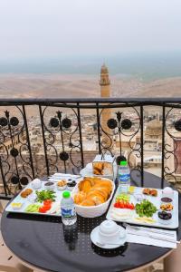 a table with two plates of food on a balcony at The Castle İnn in Mardin +46 photos