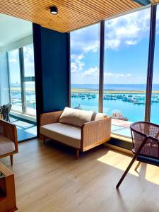 a living room with a couch and large windows at RARA HM Suites in Hulhumale